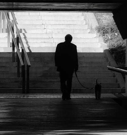 Hombre y perro subiendo una escalinata en silueta, en blanco y negro, Mataró. Fotografía fine art, edición limitada de 5 ejemplares.