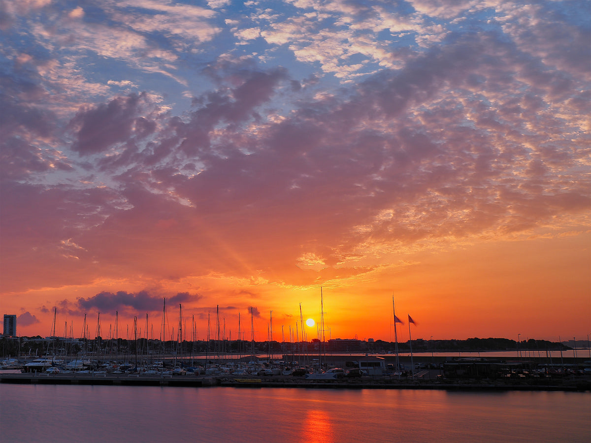 Cielo naranja y magenta sobre el puerto deportivo de Cambrils, con los mástiles en silueta. Fotografía fine art, edición limitada de 5 ejemplares.