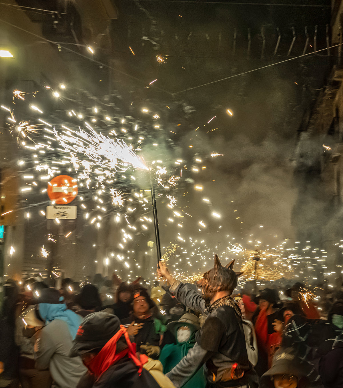 Figura con máscara de diablo alza una bengala entre la multitud en un correfoc de Mataró. Fotografía fine art, edición limitada de 5 ejemplares.